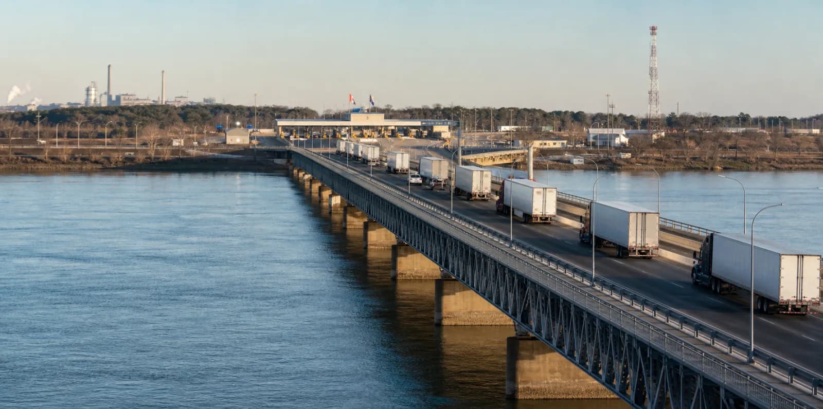 Commercial trucks crossing an international bridge toward inspection facilities.